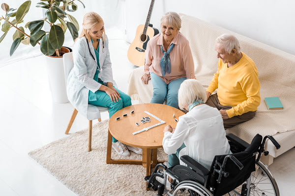 Senioren Freizeit beim Domino Spiel mit polnischer Pflegefachkraft